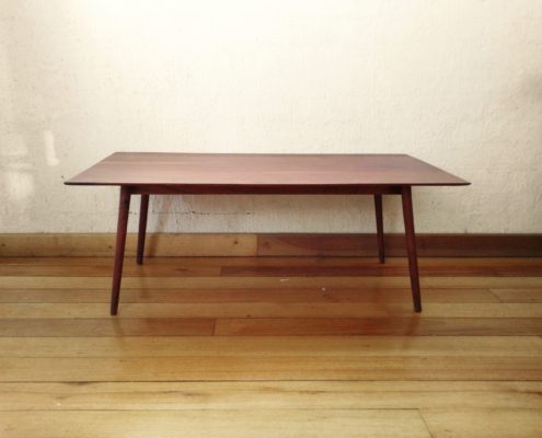Delicate coffee table out of dark reddish timber with turned and tapered legs that splay out