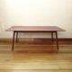 Delicate coffee table out of dark reddish timber with turned and tapered legs that splay out